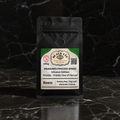 Pricklu 100g whole bean infused coffee in a matte black bag on dark marble — Black Eye Coffee Roasters